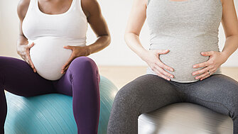 Zwei schwangere Frauen sitzen auf Pezzibällen