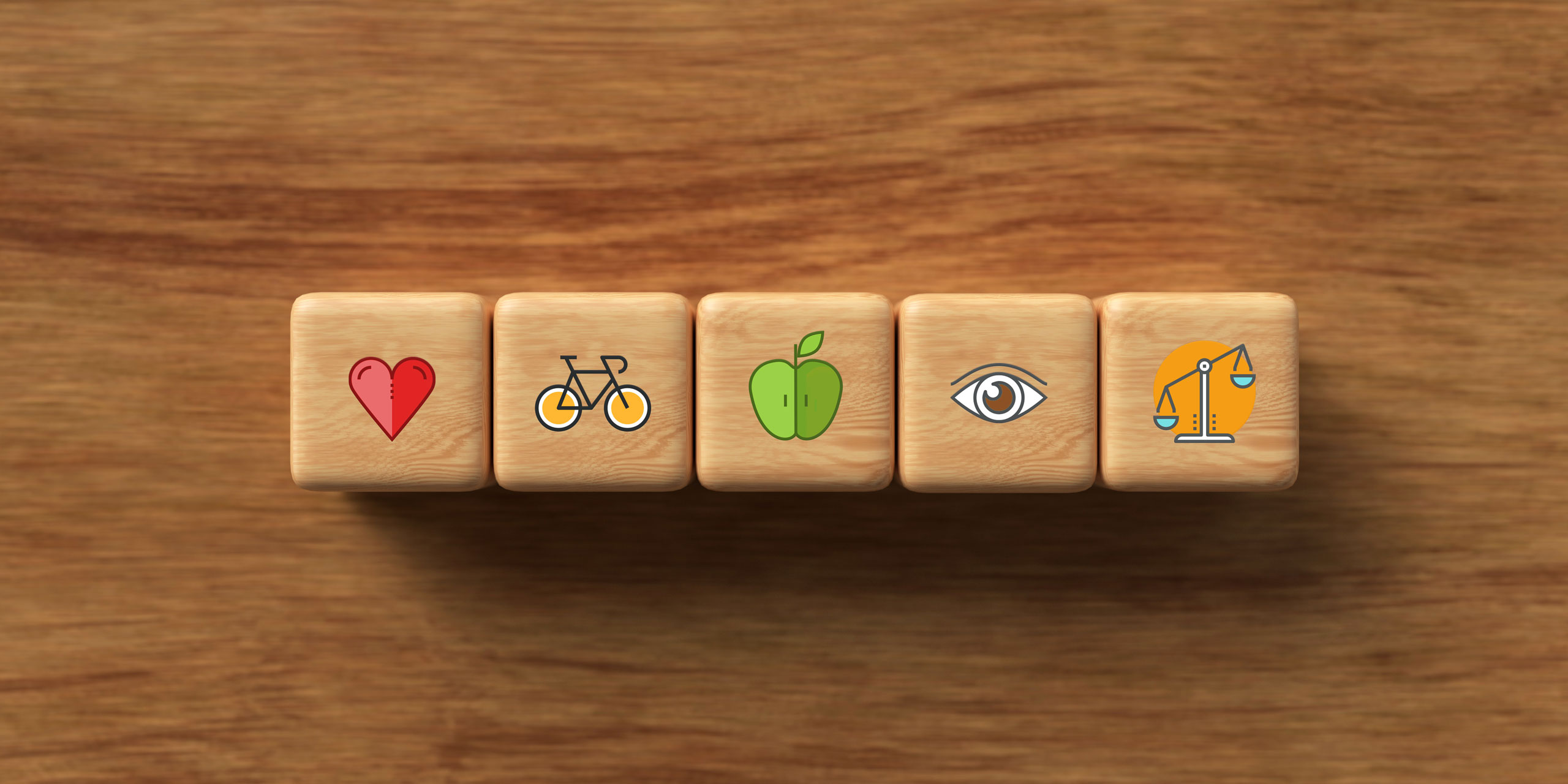 Eine Reihe von fünf Würfeln mit verschiedenen Symbolen – hier Herz, Fahrrand, Apfel, Auge und Waage.